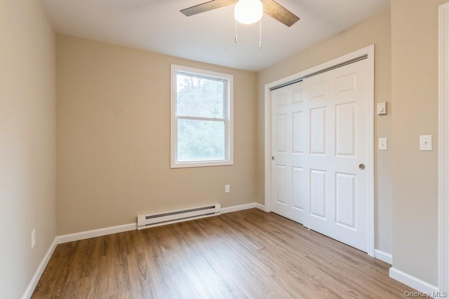 435 State Rte 55 Eldred, NY 12732 - Photo 20 of 26 an empty room with wooden floor and windows