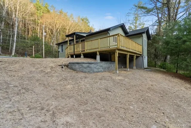 a view of a house with a yard and large tree