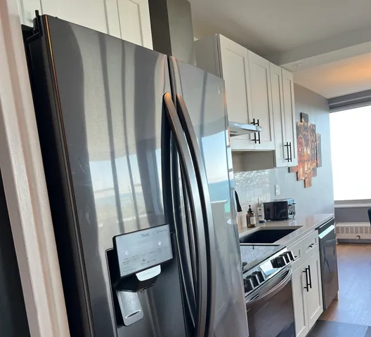 a kitchen with stainless steel appliances a refrigerator a sink a stove a microwave and cabinets