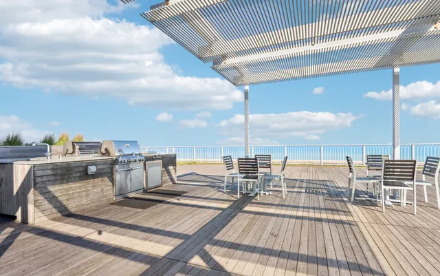 a view of roof deck with dining table and chairs