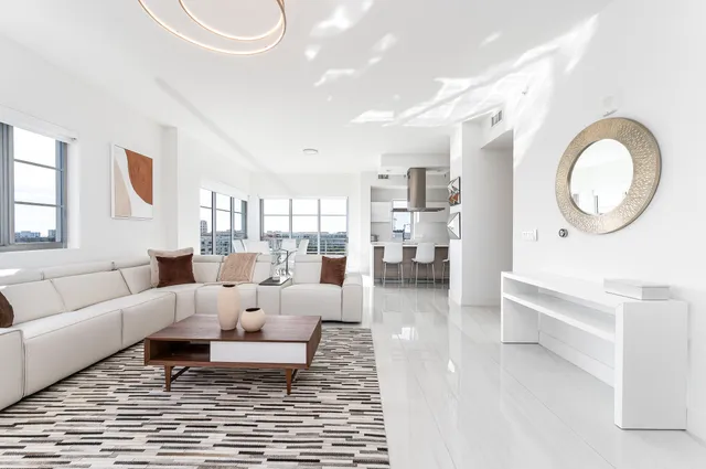 a living room with furniture a rug and a mirror