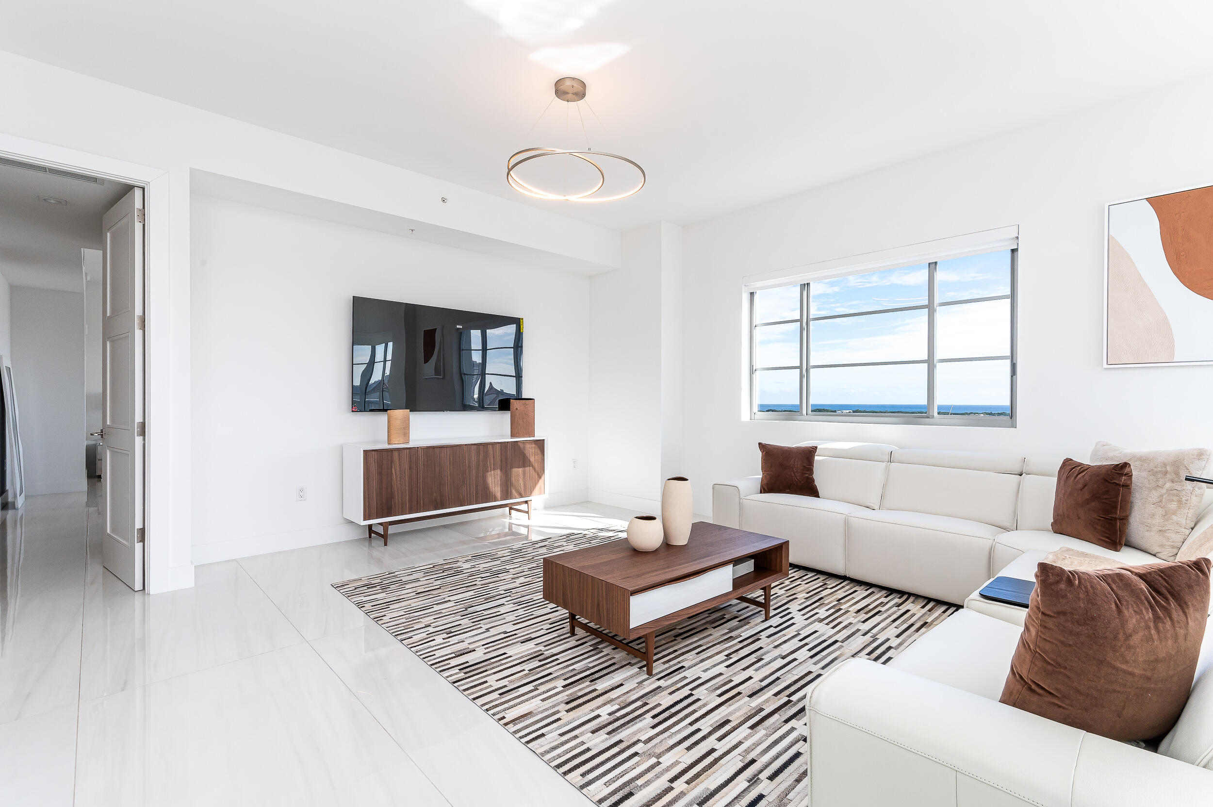 155 East Boca Raton Road, Unit 1103 Boca Raton, FL 33432 - Photo 9 of 57 a living room with a couch and a flat screen tv