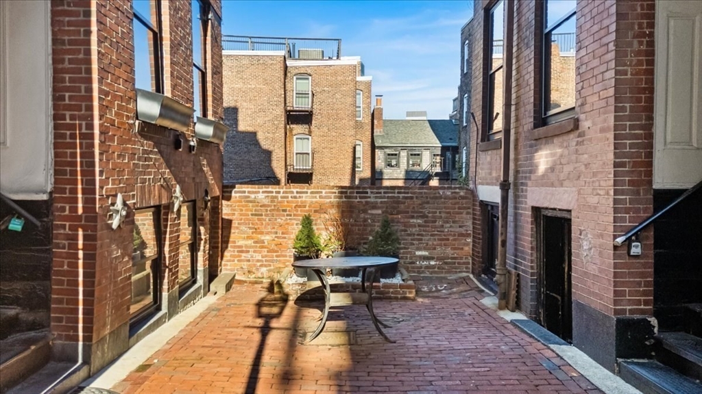 6 Goodwin Place, Unit 4 Boston, MA 02114 - Photo 21 of 24 a balcony with outdoor seating and wooden floor