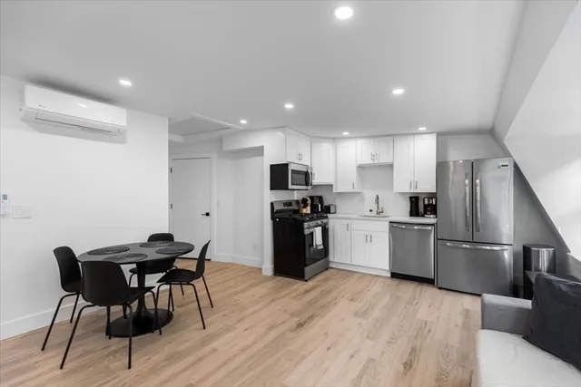 a kitchen with a sink a microwave a refrigerator and chairs