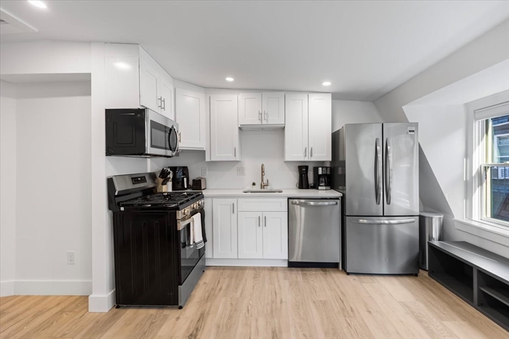 6 Goodwin Place, Unit 4 Boston, MA 02114 - Photo 10 of 24 a kitchen with a refrigerator stove and wooden floor