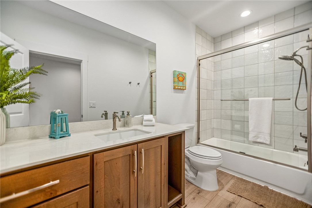 96 Circle Hook Port O'Connor, TX 77982 - Photo 14 of 36 a bathroom with a granite countertop sink a toilet a mirror and shower