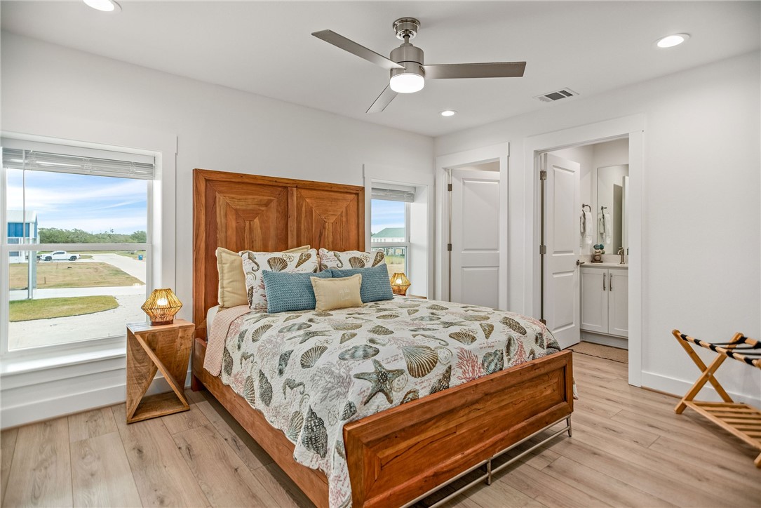 96 Circle Hook Port O'Connor, TX 77982 - Photo 21 of 36 a bedroom with a bed and a large window with wooden floor