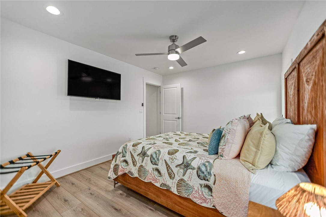 96 Circle Hook Port O'Connor, TX 77982 - Photo 23 of 36 a bedroom with a bed a flat screen tv and a chandelier