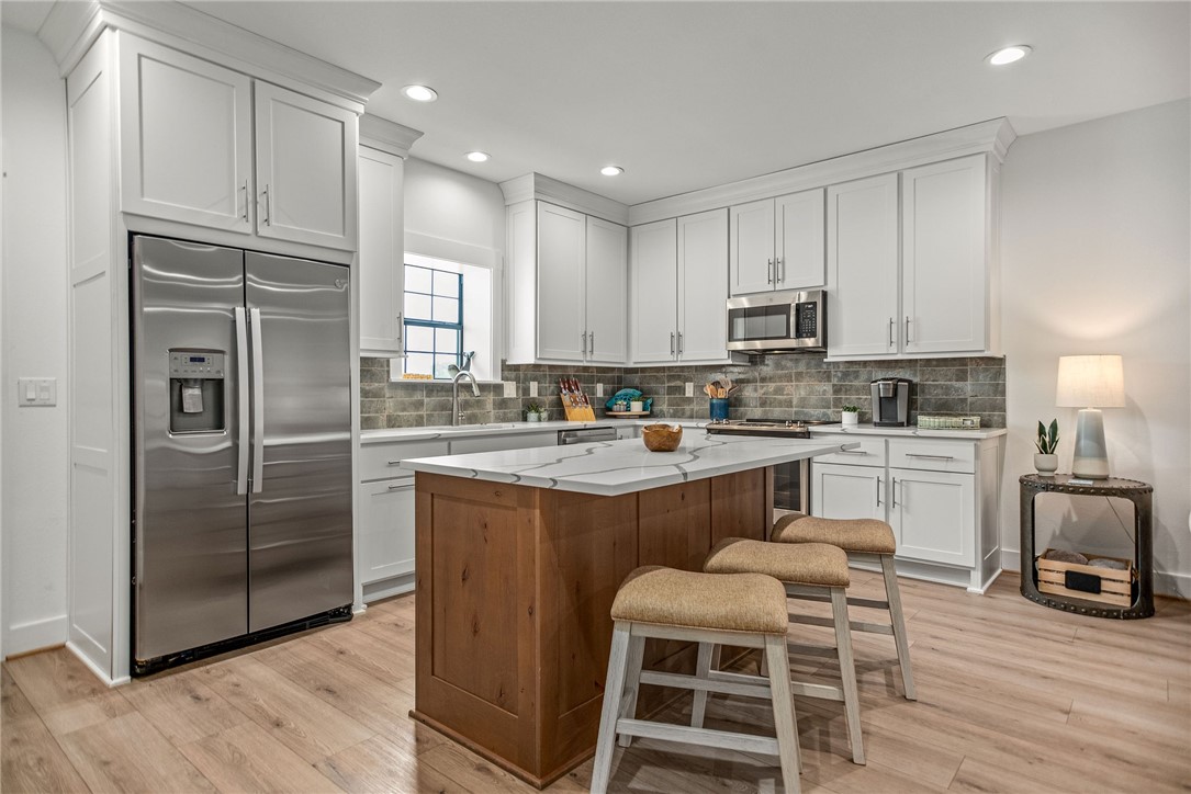 96 Circle Hook Port O'Connor, TX 77982 - Photo 5 of 36 a kitchen with kitchen island granite countertop wooden cabinets and stainless steel appliances