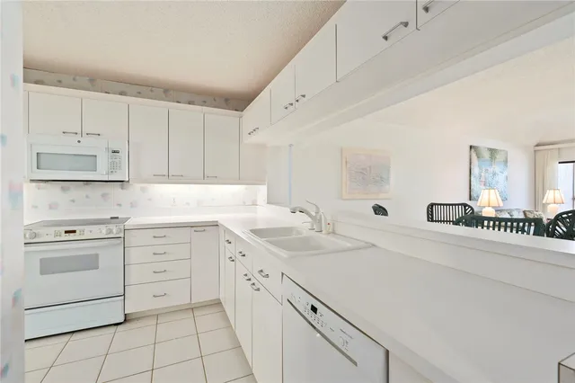 a kitchen with white cabinets appliances and a sink