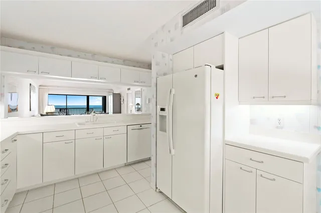 a kitchen with white cabinets and white appliances