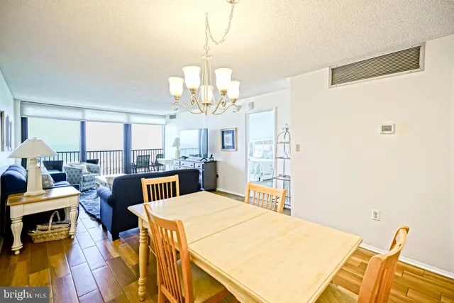 a view of a dining room with furniture a chandelier and wooden floor