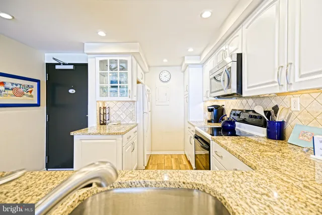 a kitchen with stainless steel appliances granite countertop a sink and a stove top oven