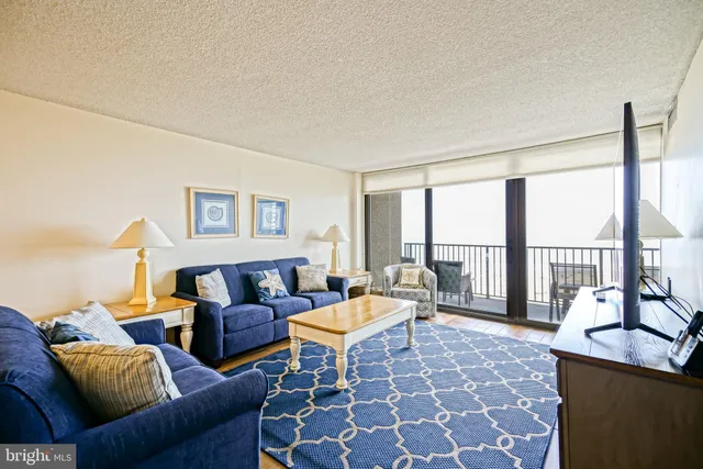 a living room with furniture and a floor to ceiling window