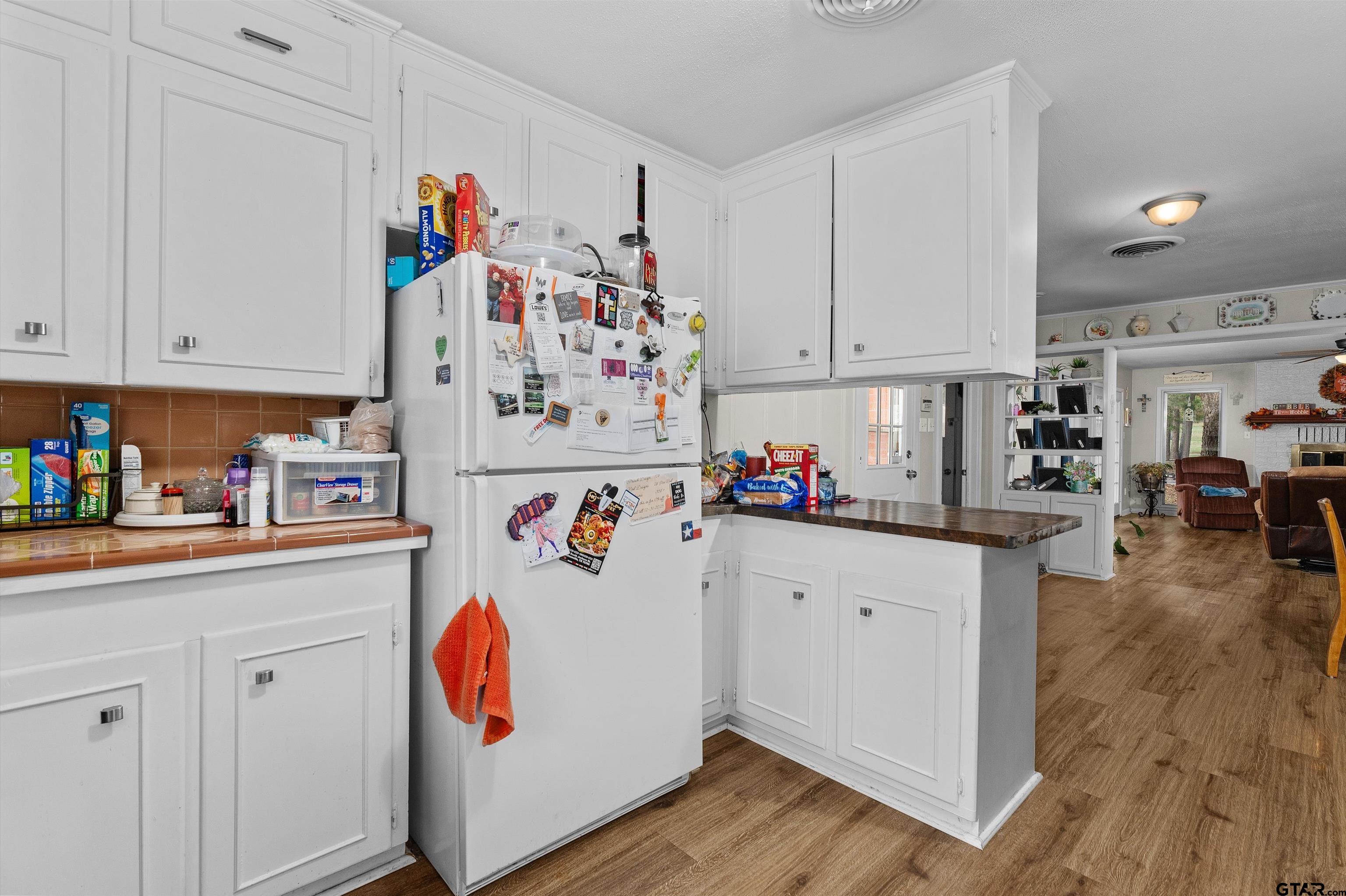 387 Hill Avenue Rusk, TX 75785 - Photo 11 of 26 a kitchen with a refrigerator and white cabinets