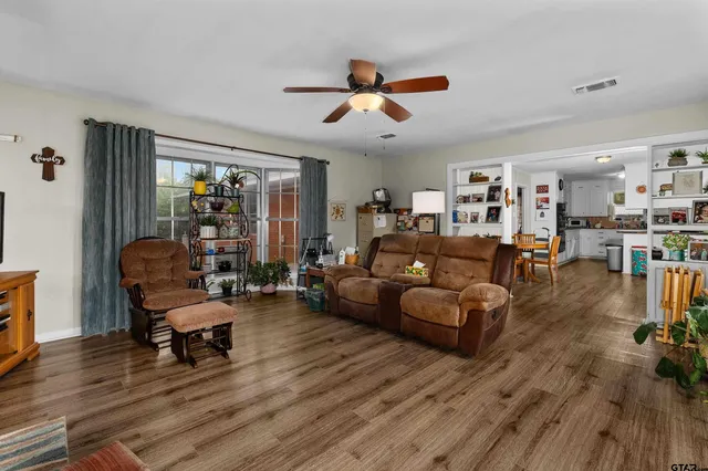 a living room with furniture and a wooden floor