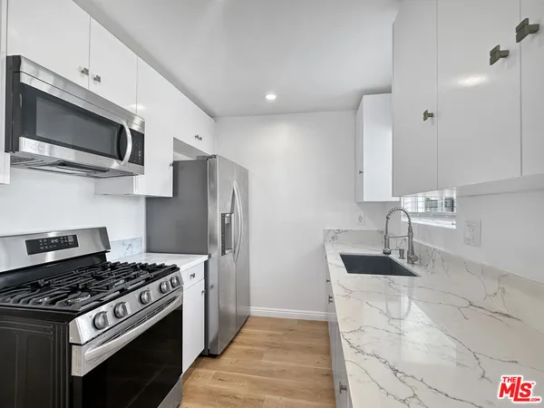 a kitchen with stainless steel appliances a sink a stove and microwave