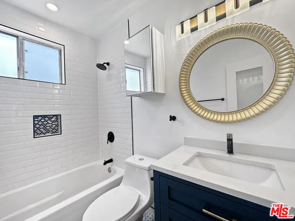 a bathroom with a toilet a sink and a mirror