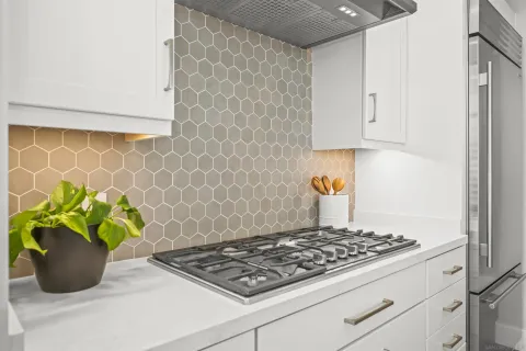 a kitchen with a stove and a white wooden cabinets