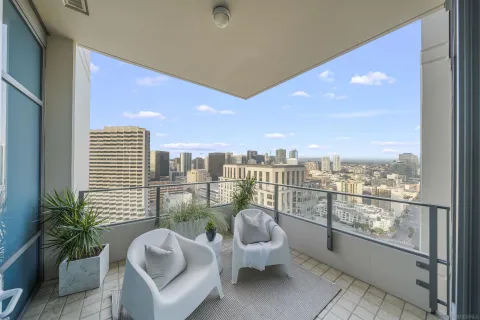 a view of a balcony with chairs and a potted plant