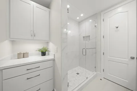 a bathroom with a granite countertop sink a vanity and shower
