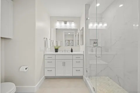 a spacious bathroom with a shower a sink a mirror and a shower