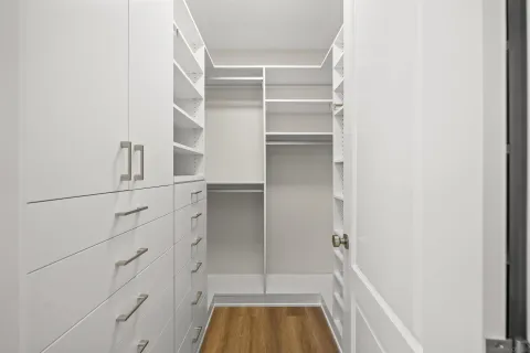 a view of walk in closet with empty racks