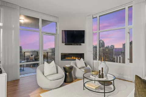 a living room with furniture a flat screen tv and a fireplace