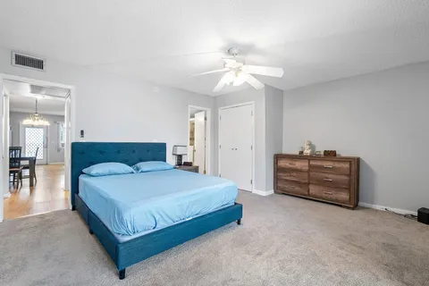 a spacious bedroom with a bed and a chandelier