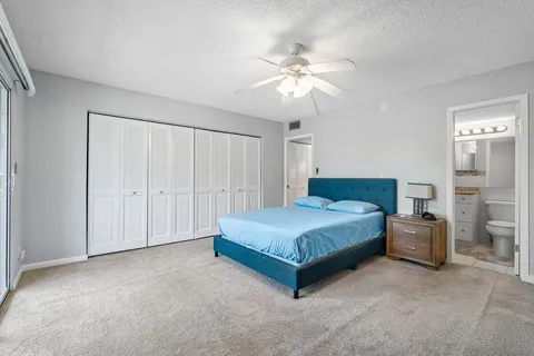 a spacious bedroom with a bed and a chandelier