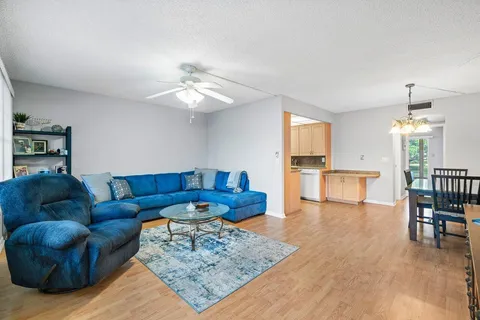 a living room with furniture and a dining table with kitchen view