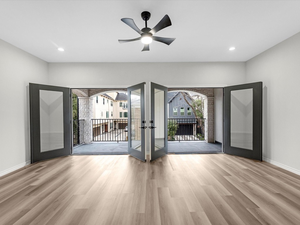 1319 West Bell Street Houston, TX 77019 - Photo 41 of 50 Open game room with light vinyl flooring, featuring double doors leading to an expansive terrace. Ceiling fan and recessed lighting enhance the modern feel, offering a view of neighboring homes.