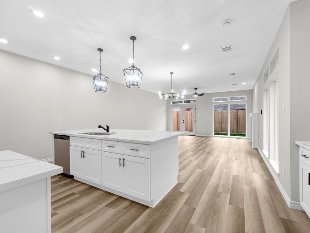 1319 West Bell Street Houston, TX 77019 - Photo 8 of 50 *Note* This photo is virtually staged*
Bright, spacious room with light wood flooring, neutral walls, and recessed lighting. Features a ceiling fan and double French doors leading to a private balcony with views of neighboring buildings.