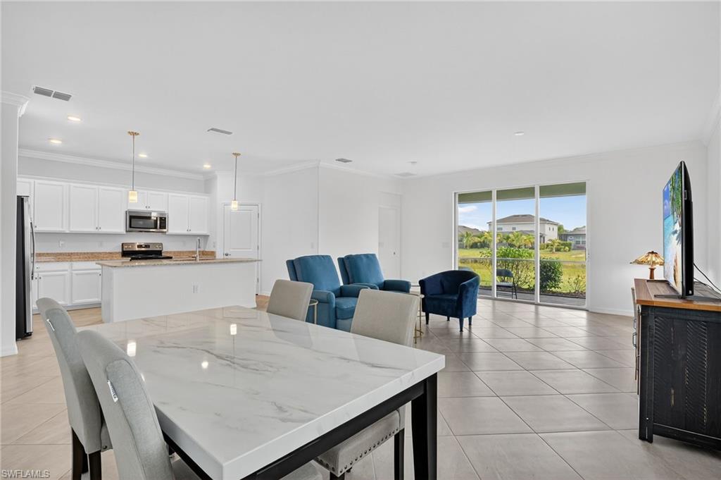 2126 Hamlin Street Naples, FL 34120 - Photo 7 of 38 a view of kitchen with dining table and chairs