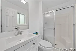 a bathroom with a sink a mirror a toilet and shower