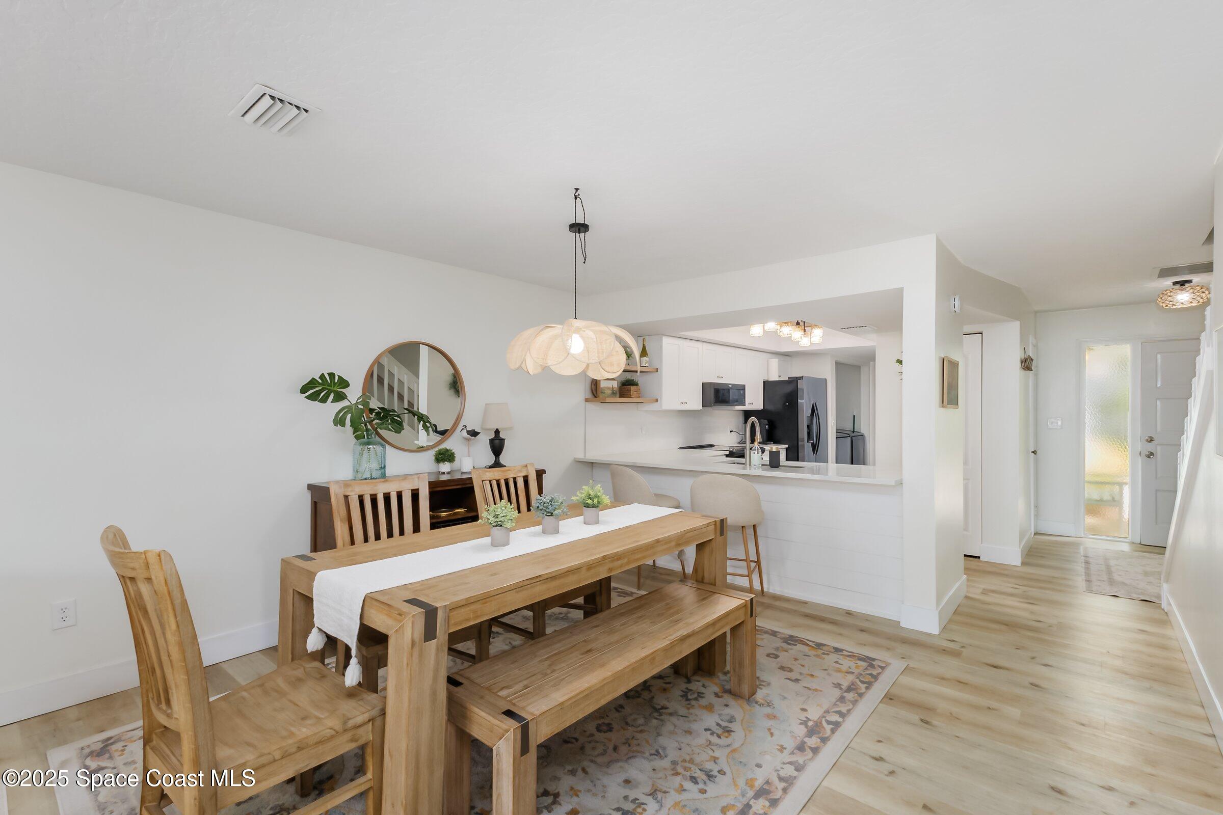 24 Olive Street Cocoa Beach, FL 32931 - Photo 12 of 50 a living room with furniture a rug and a chandelier