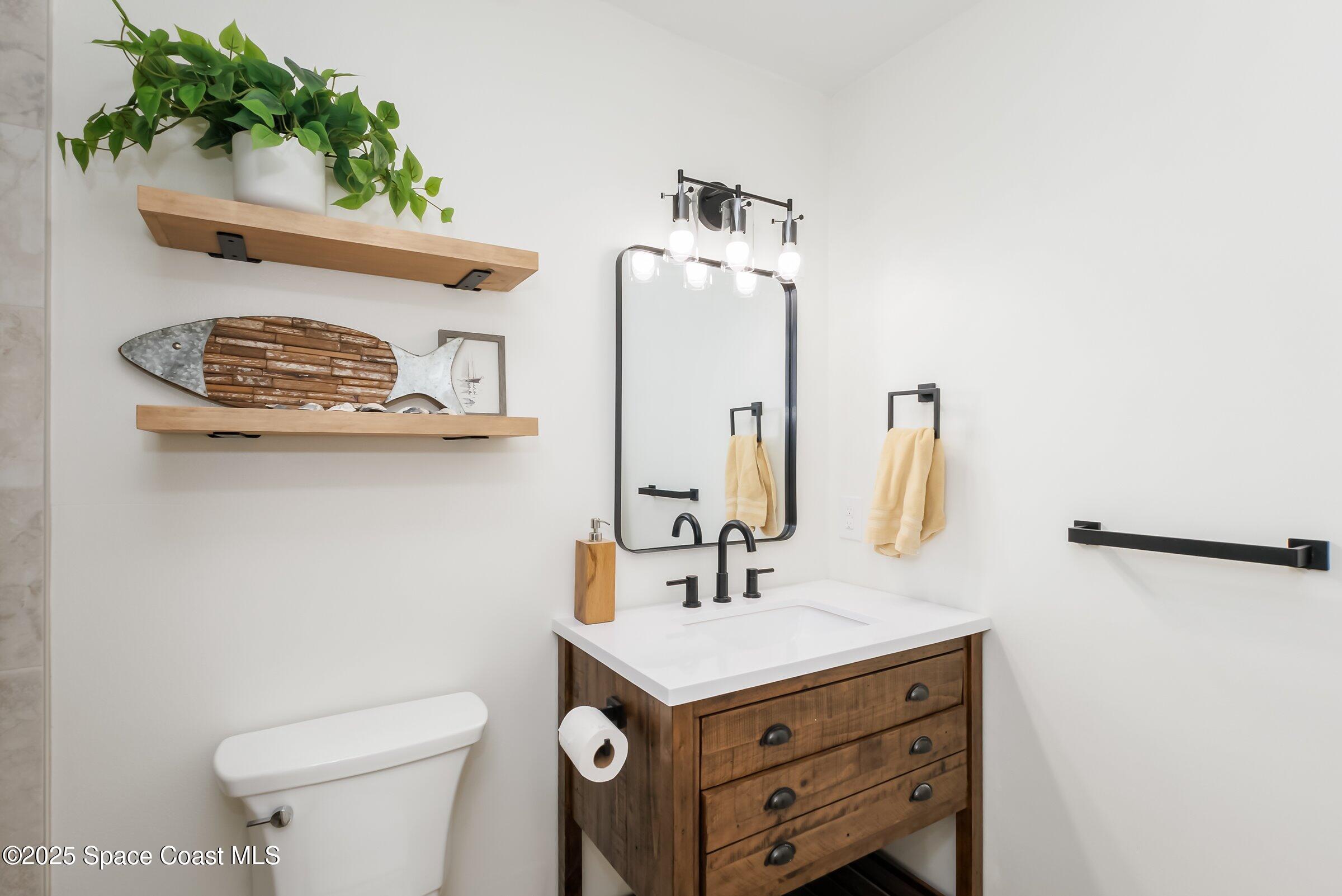 24 Olive Street Cocoa Beach, FL 32931 - Photo 25 of 50 a bathroom with a sink a toilet and vanity