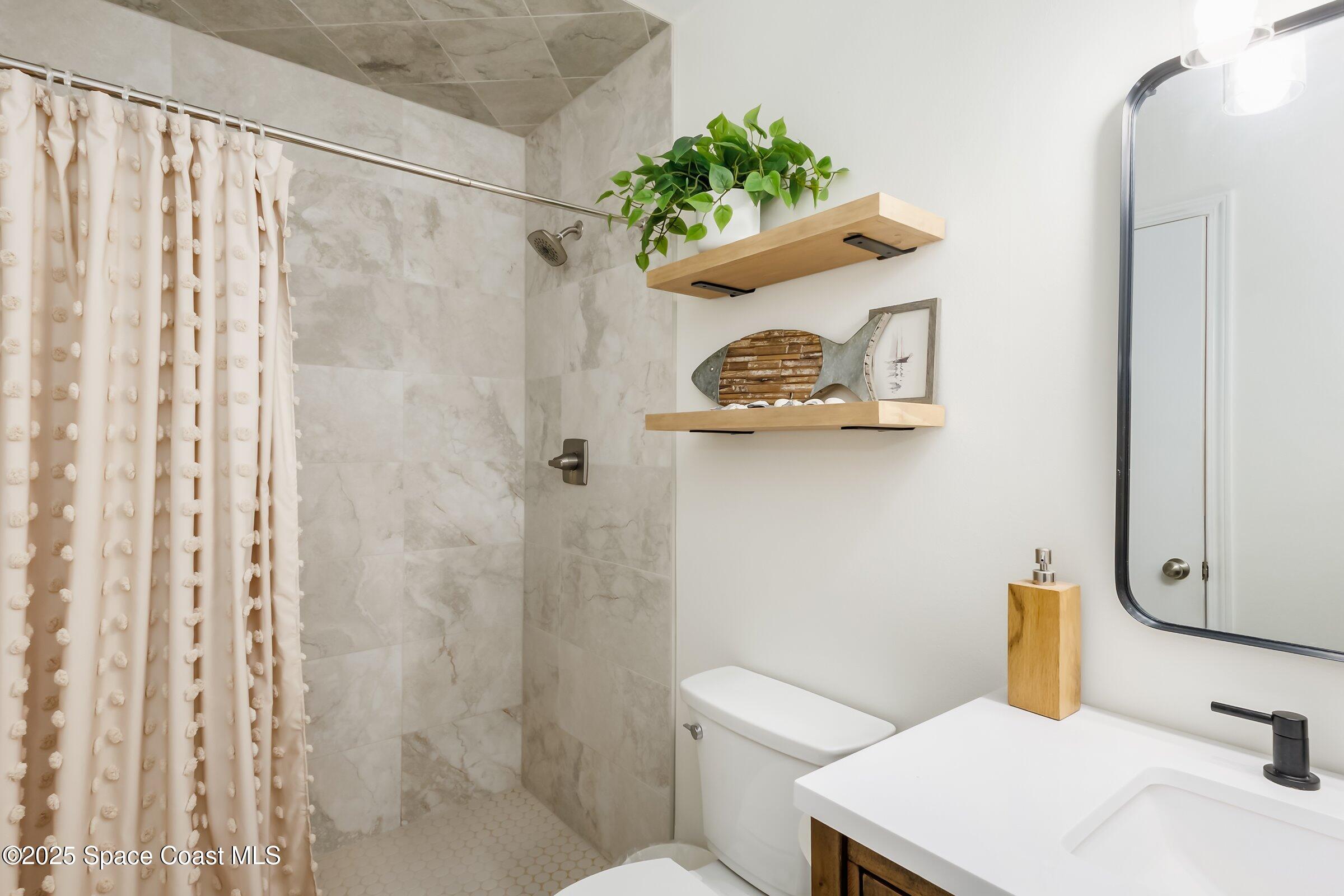 24 Olive Street Cocoa Beach, FL 32931 - Photo 26 of 50 a bathroom with a sink mirror and toilet