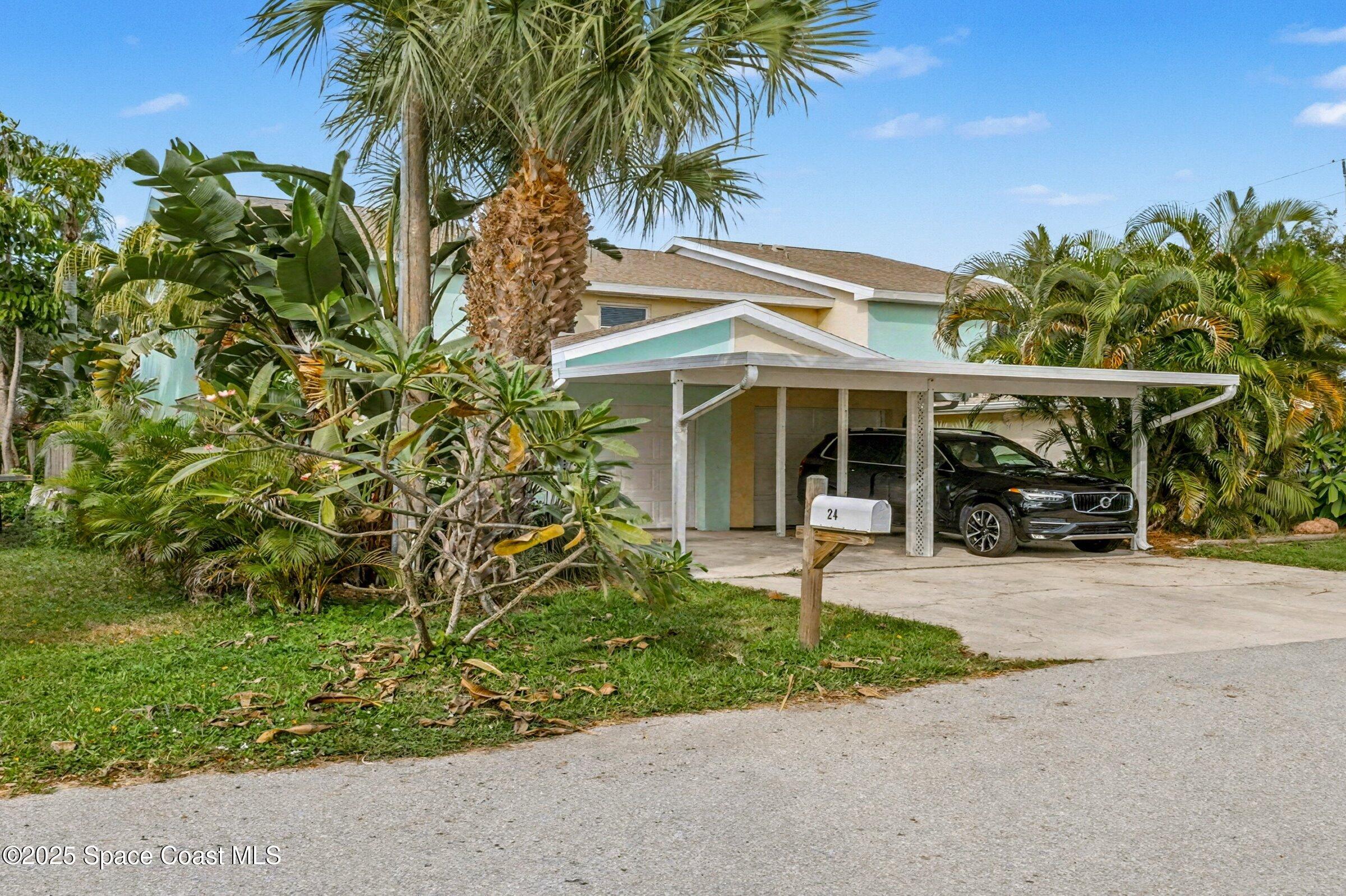 24 Olive Street Cocoa Beach, FL 32931 - Photo 3 of 50 front view of a house with a yard and potted plants