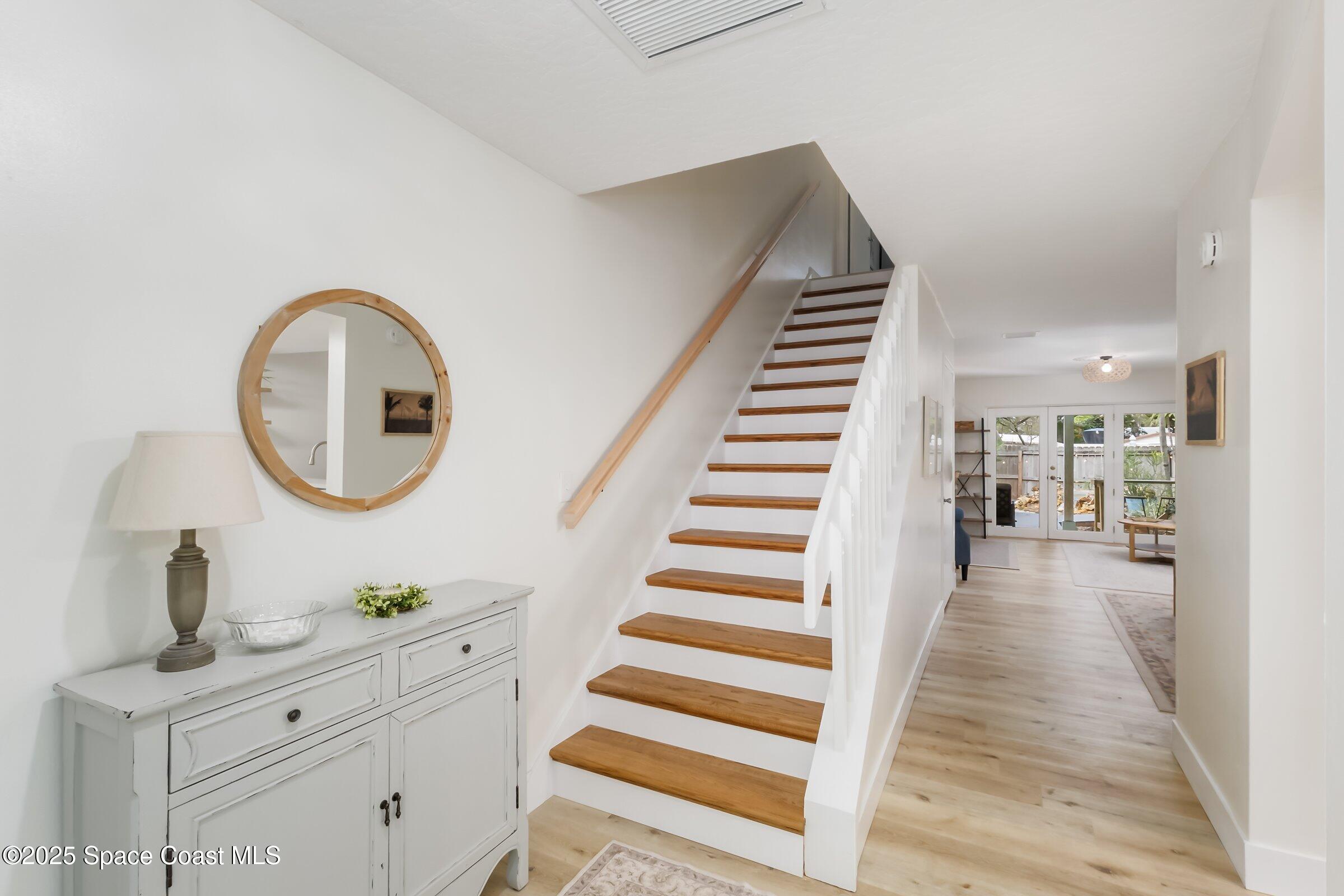 24 Olive Street Cocoa Beach, FL 32931 - Photo 9 of 50 a view of a hallway with wooden floor and staircase
