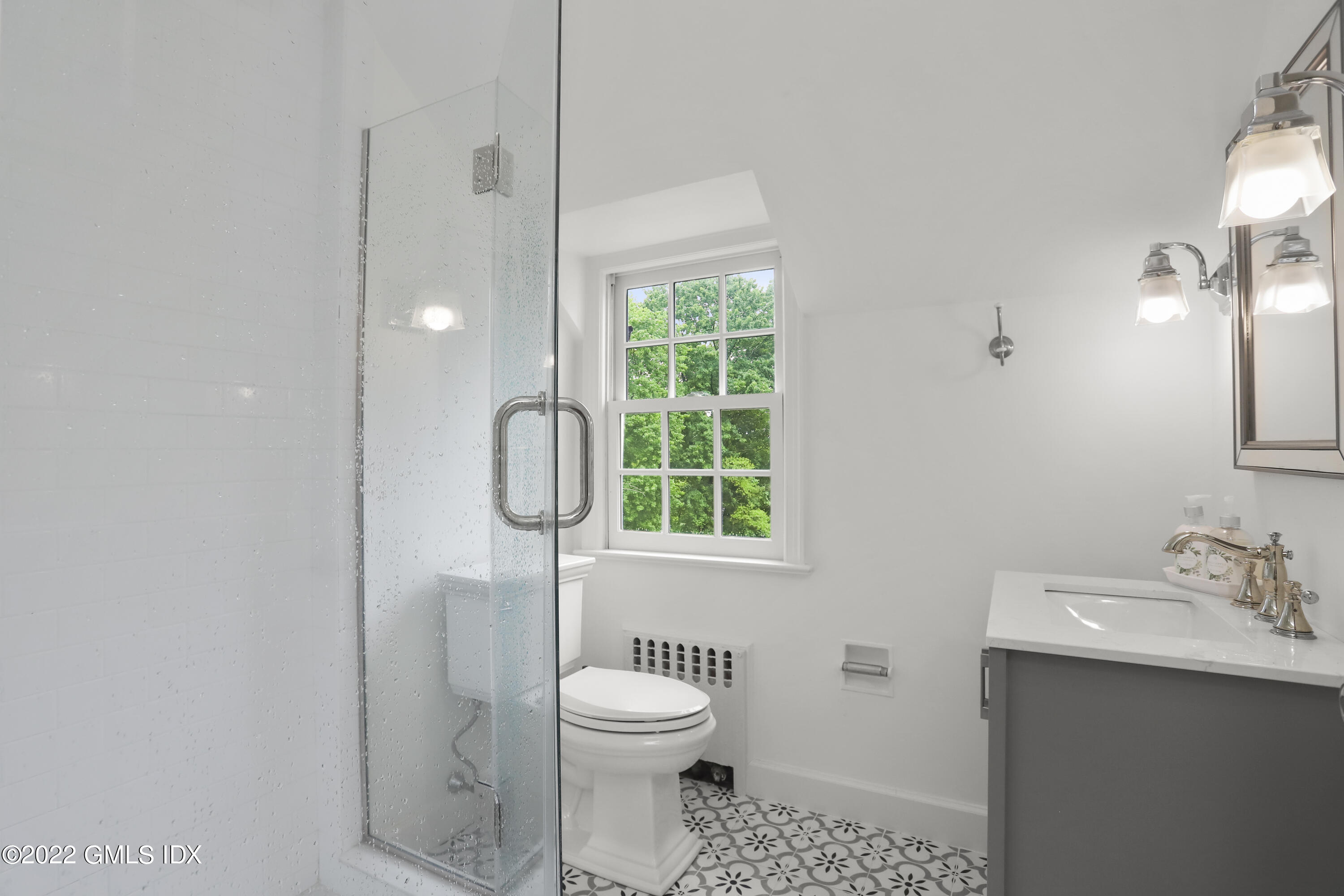 331 Round Hill Road Greenwich, CT 06831 - Photo 17 of 28 a bathroom with a toilet a sink a mirror and a window