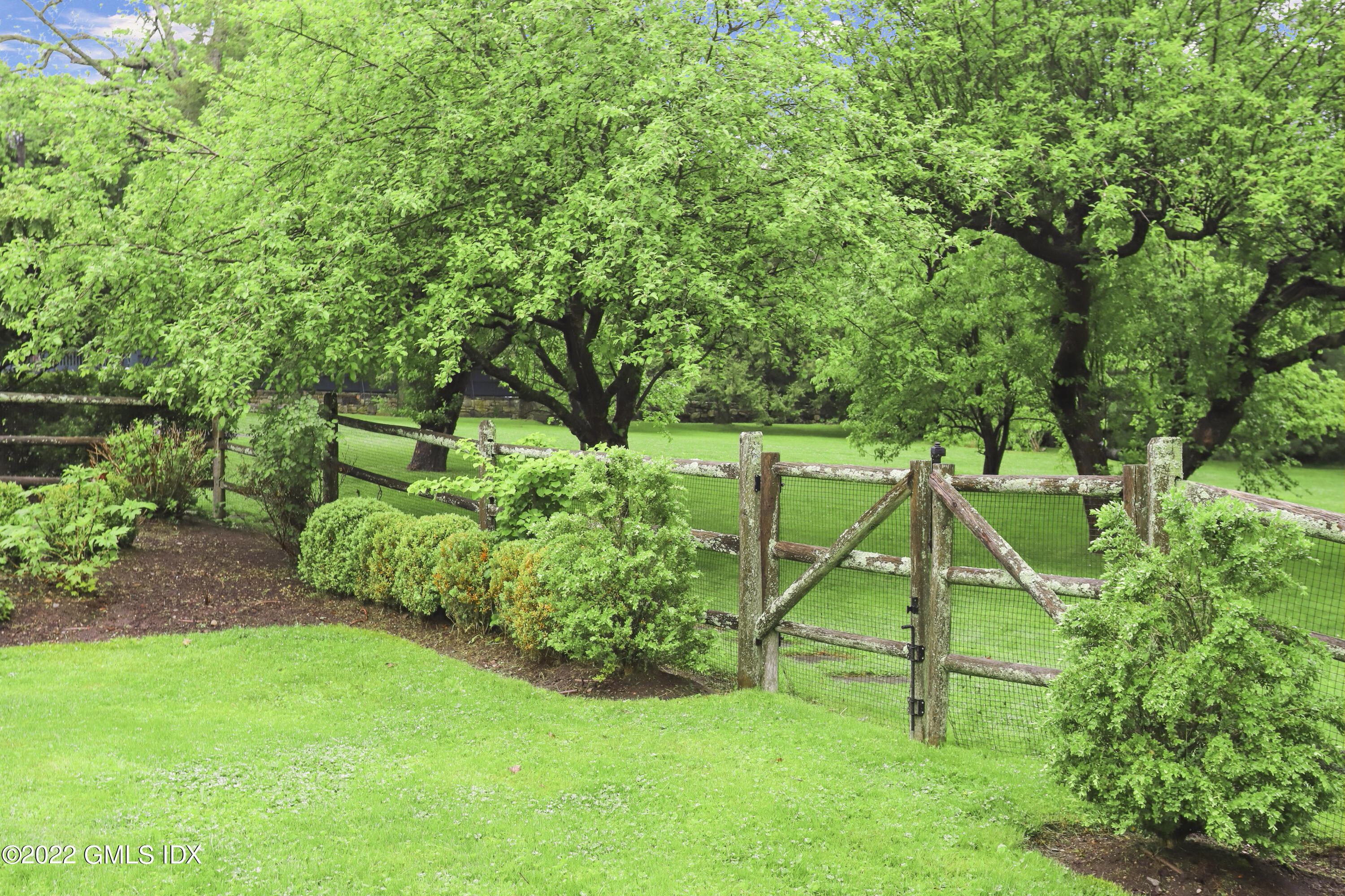 331 Round Hill Road Greenwich, CT 06831 - Photo 24 of 28 a view of a backyard with a slide trees and wooden fence