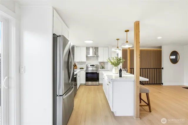 a kitchen with a refrigerator a oven and a sink