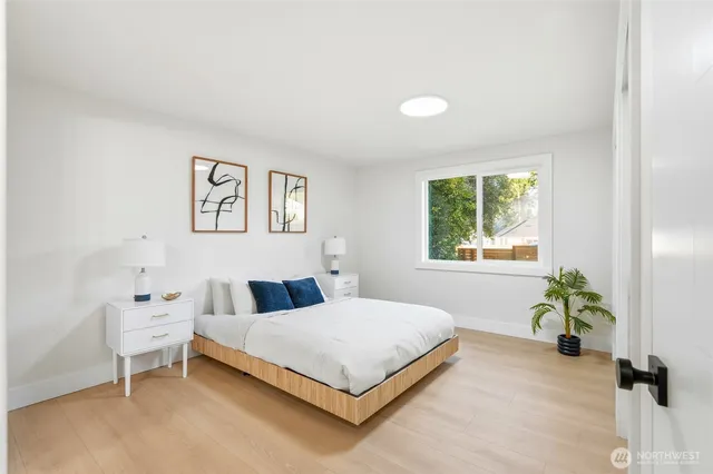 a bedroom with a bed and painting on the wall