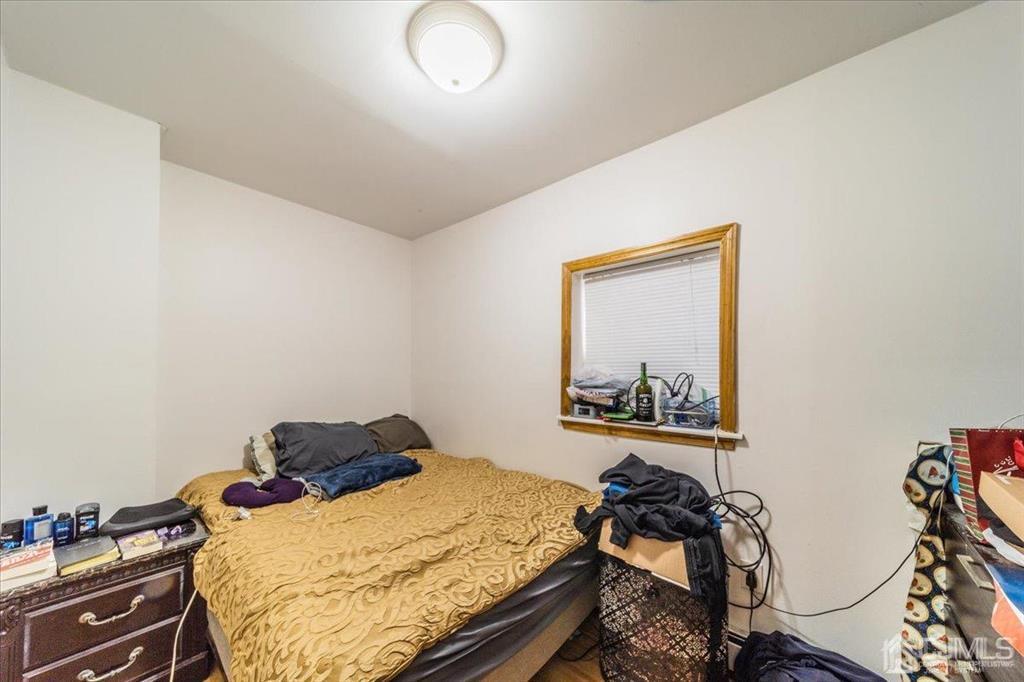 28 Union Street Carteret, NJ 07008 - Photo 22 of 25 a bedroom with a bed and wooden floor