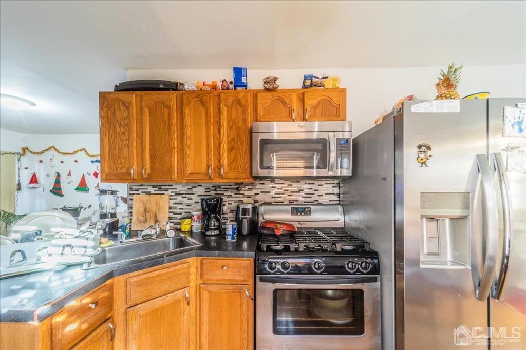 28 Union Street Carteret, NJ 07008 - Photo 5 of 25 a kitchen with granite countertop a sink stove and refrigerator