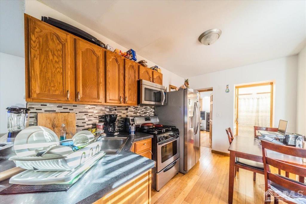 28 Union Street Carteret, NJ 07008 - Photo 6 of 25 a kitchen with stainless steel appliances granite countertop a stove a sink and a refrigerator