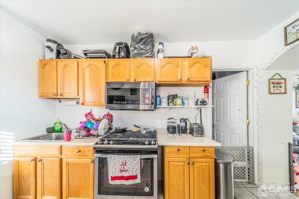 28 Union Street Carteret, NJ 07008 - Photo 8 of 25 a kitchen with stainless steel appliances granite countertop a stove a sink and a refrigerator