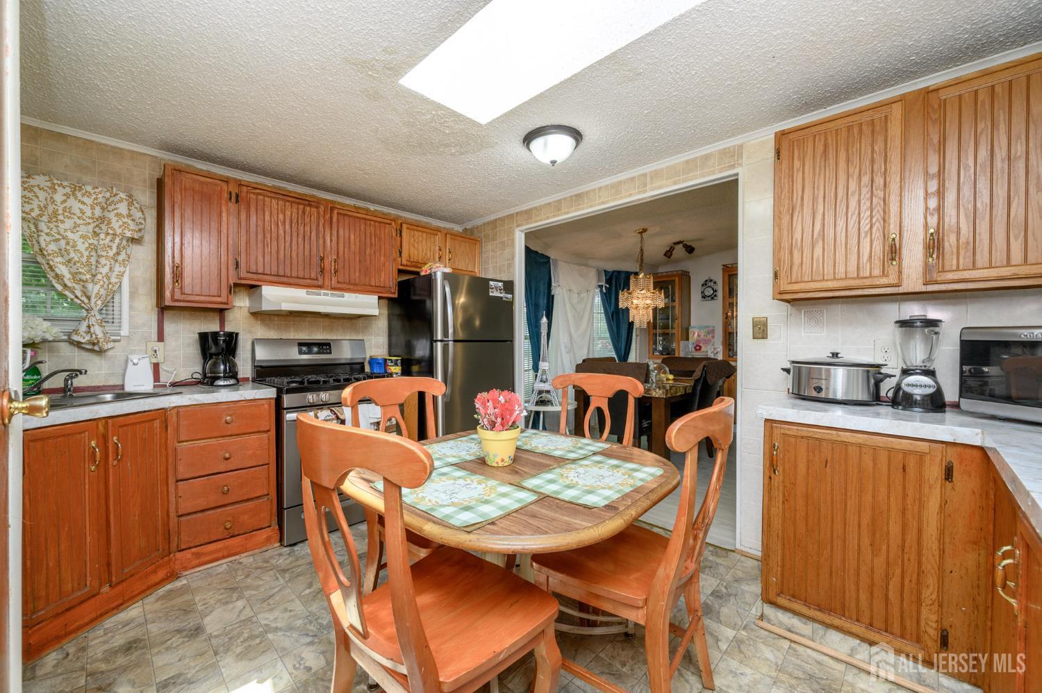 8 Snow Chief Court Howell, NJ 07731 - Photo 11 of 26 a kitchen with stainless steel appliances granite countertop a sink a stove a refrigerator cabinets and dining table
