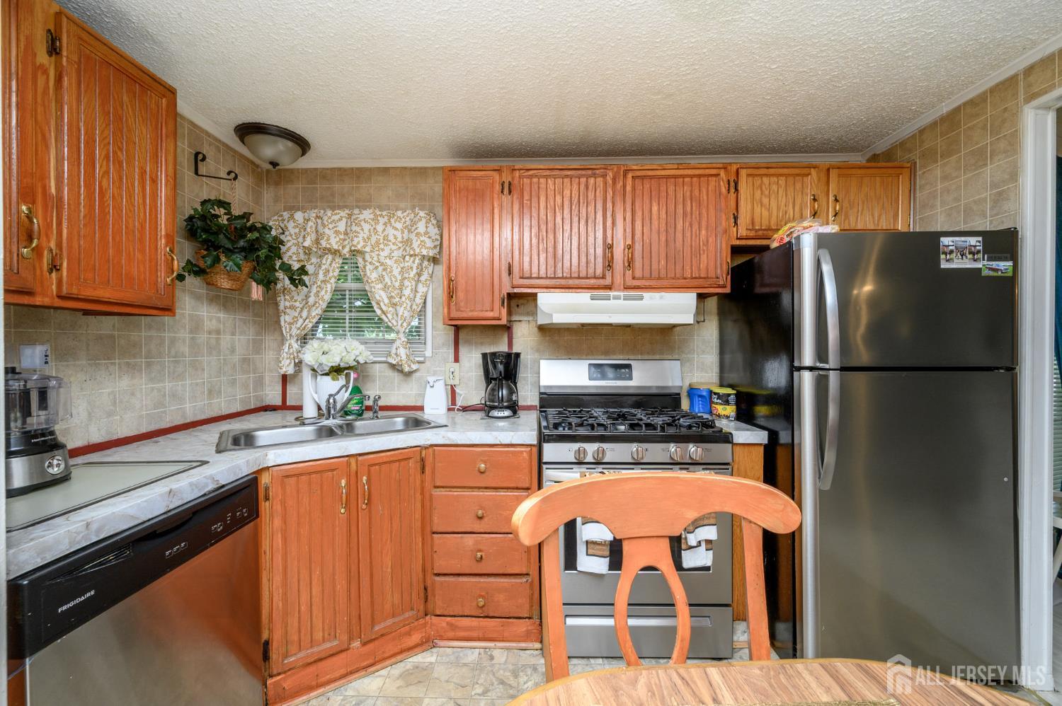 8 Snow Chief Court Howell, NJ 07731 - Photo 12 of 26 a kitchen with granite countertop a refrigerator a sink and dishwasher